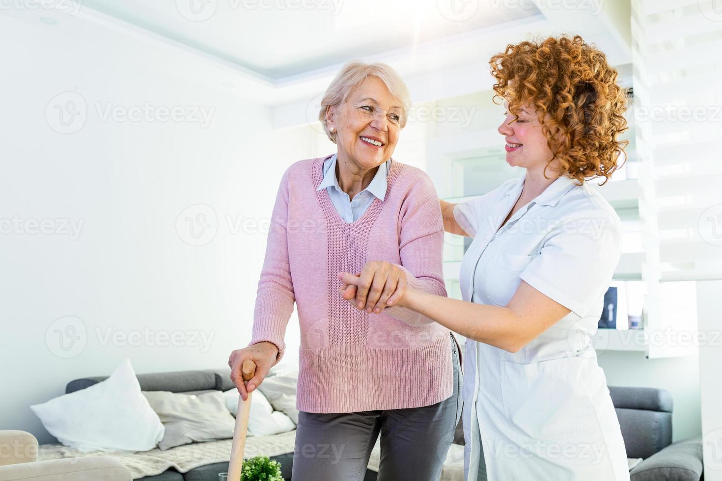 giovane badante supporto anziano Disabilitato donna con a piedi bastone. ritratto di contento femmina badante e anziano donna a piedi insieme a casa. professionale badante assunzione cura di anziano donna. foto