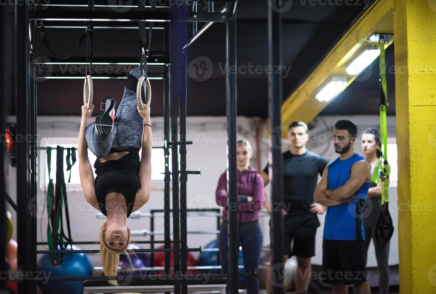 donna Lavorando su con personale allenatore su ginnastica anelli foto