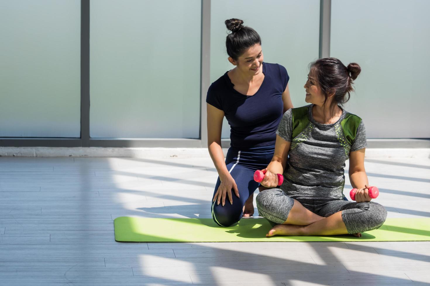 Due asiatico donne fare yoga insieme a un' palestra. foto