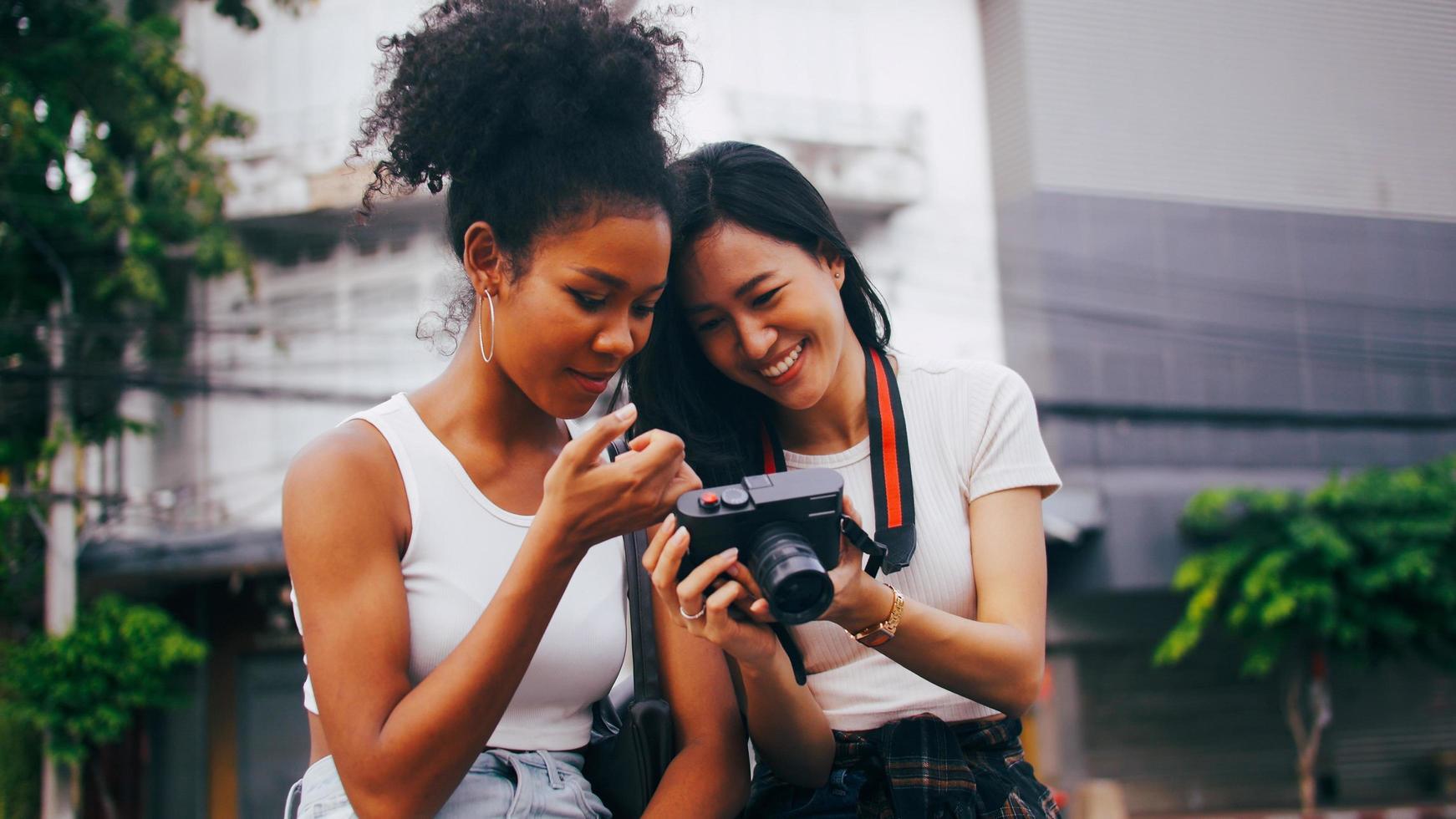 Due amiche godendo il città tour. giovane turisti avendo divertimento assunzione immagini insieme. foto