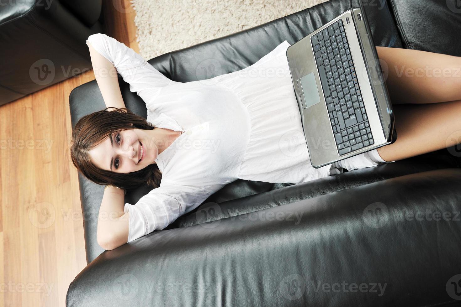 ragazza opera su il computer portatile a casa foto