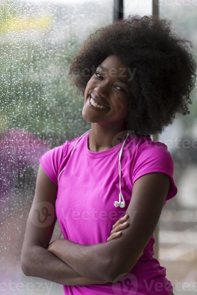 ritratto di giovane afro americano donna nel Palestra mentre ascoltando musica foto