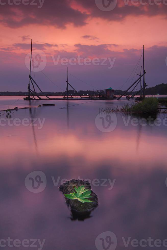 sera Visualizza a tramonto con profondità di campo rocce e le foglie foto