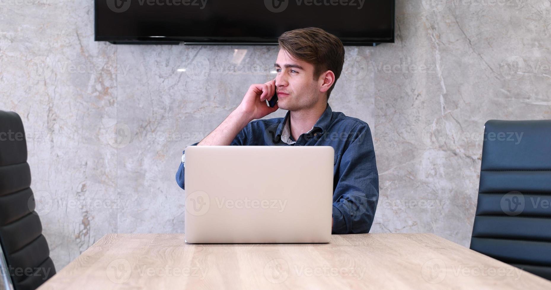 uomo d'affari che lavora utilizzando un laptop nell'ufficio di avvio foto