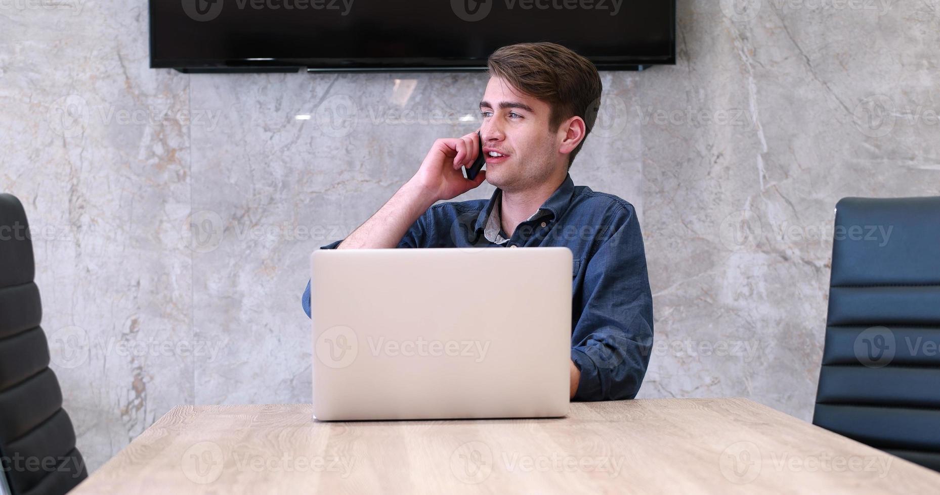 uomo d'affari che lavora utilizzando un laptop nell'ufficio di avvio foto