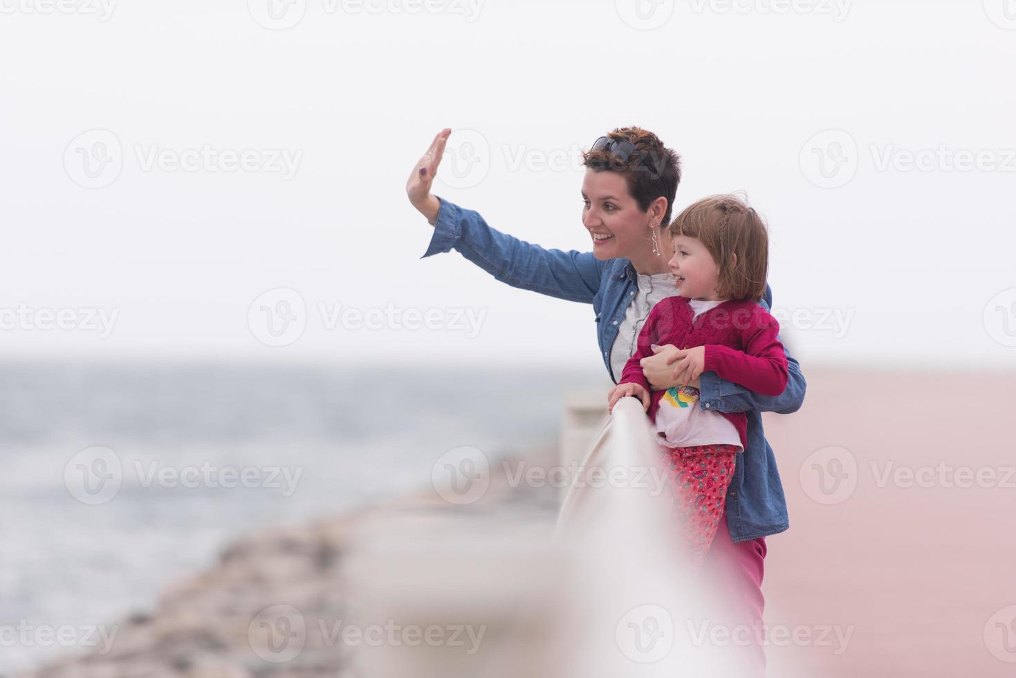 madre e carino poco ragazza su il lungomare di il mare foto