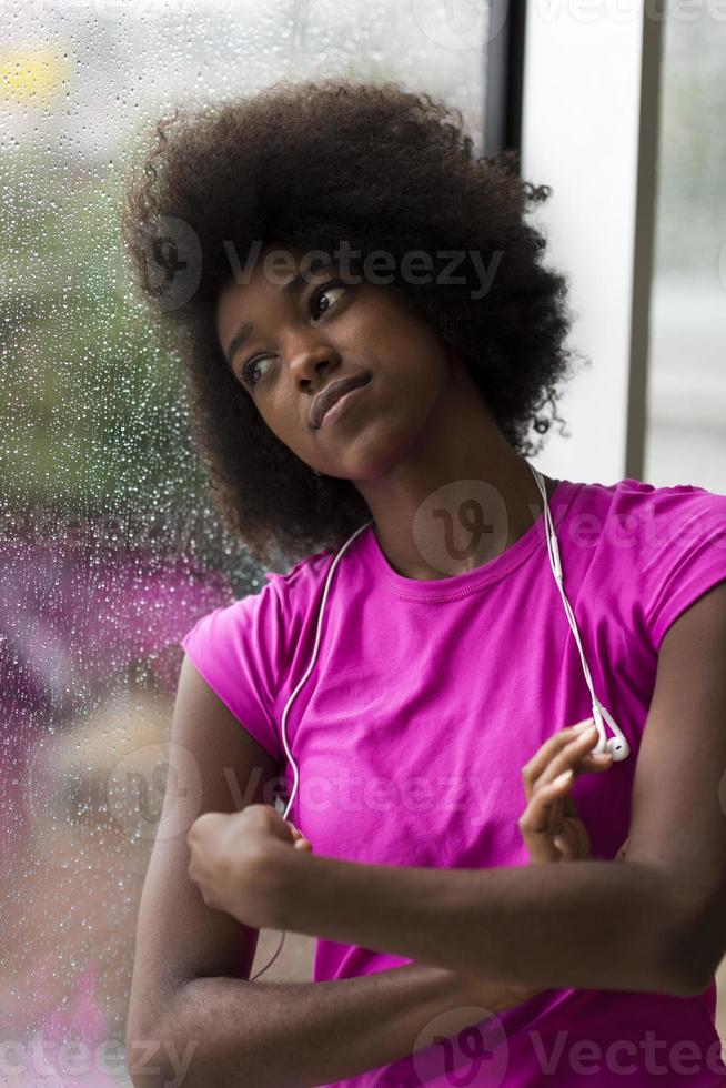 ritratto di giovane afro americano donna nel Palestra mentre ascoltando musica foto