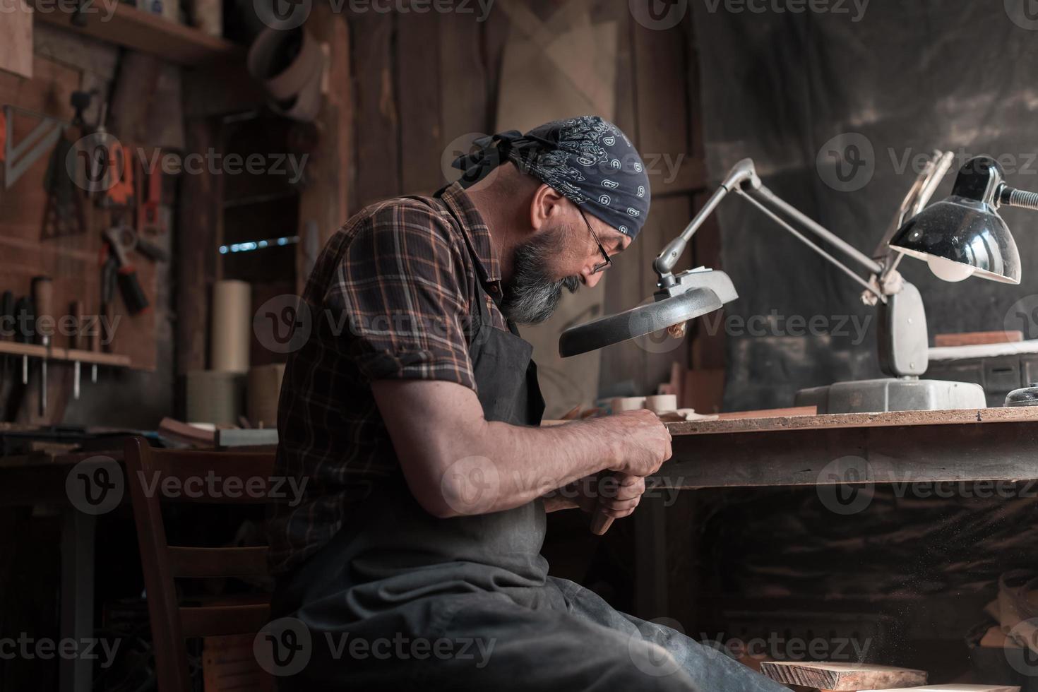 cucchiaio maestro nel il suo laboratorio con di legno prodotti e utensili foto