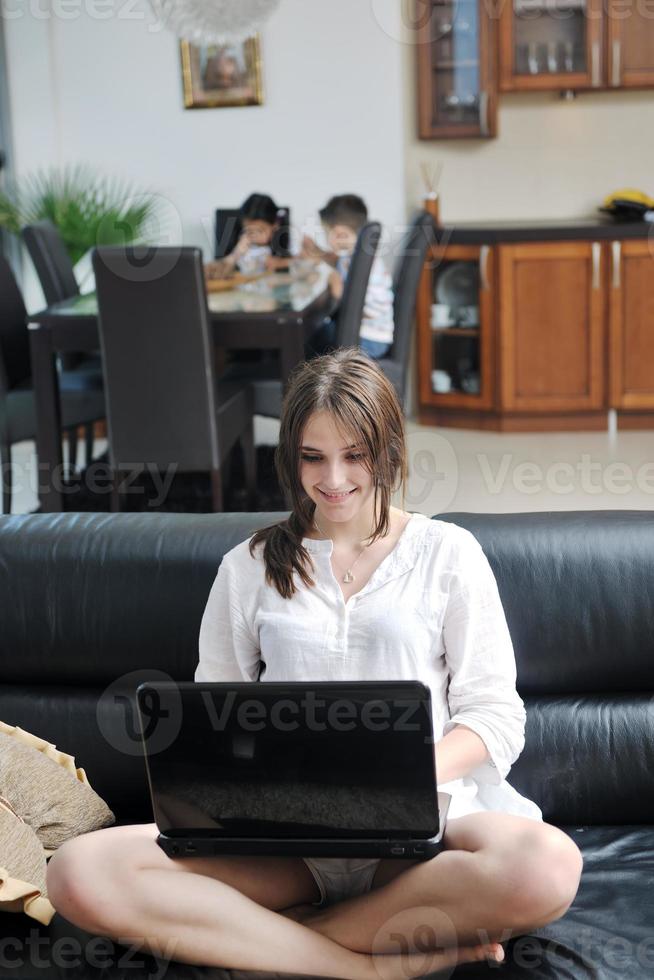 contento giovane famiglia avere divertimento e Lavorando su il computer portatile a casa foto