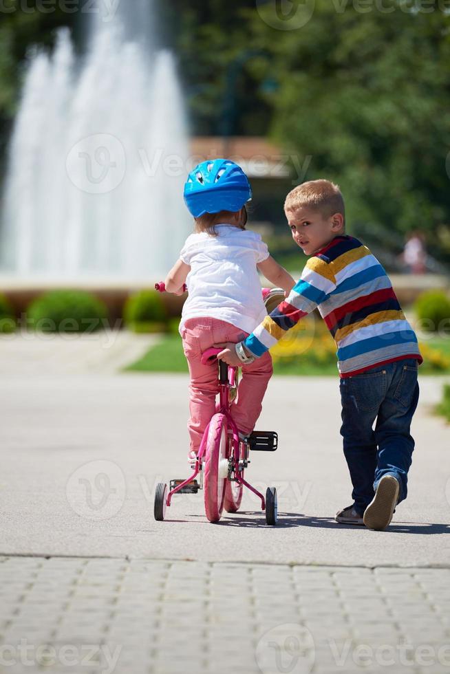 ragazzo e ragazza nel parco apprendimento per cavalcata un' bicicletta foto