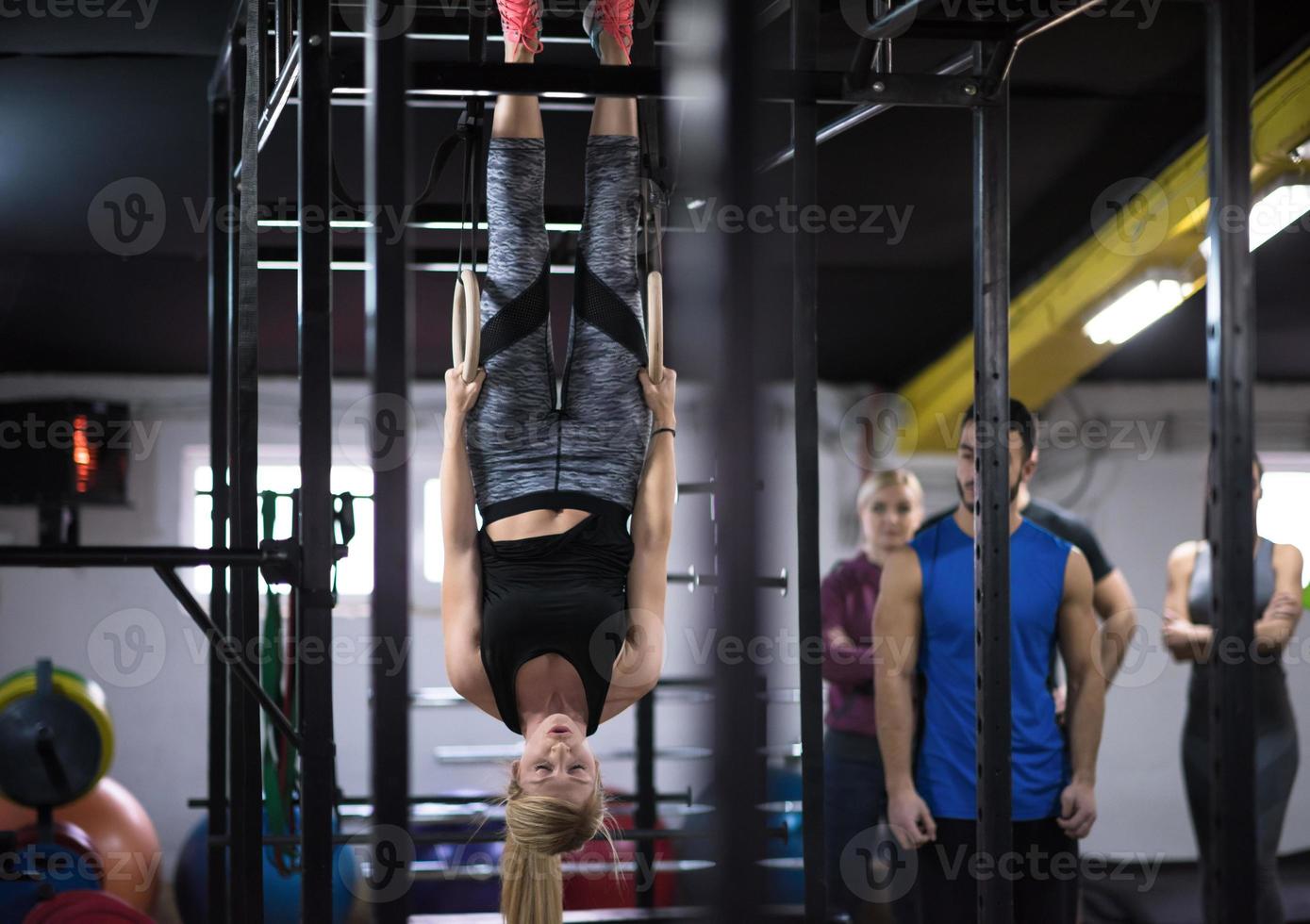 donna Lavorando su con personale allenatore su ginnastica anelli foto