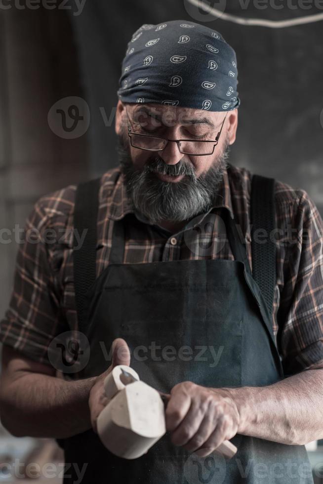 cucchiaio maestro nel il suo laboratorio con di legno prodotti e utensili foto