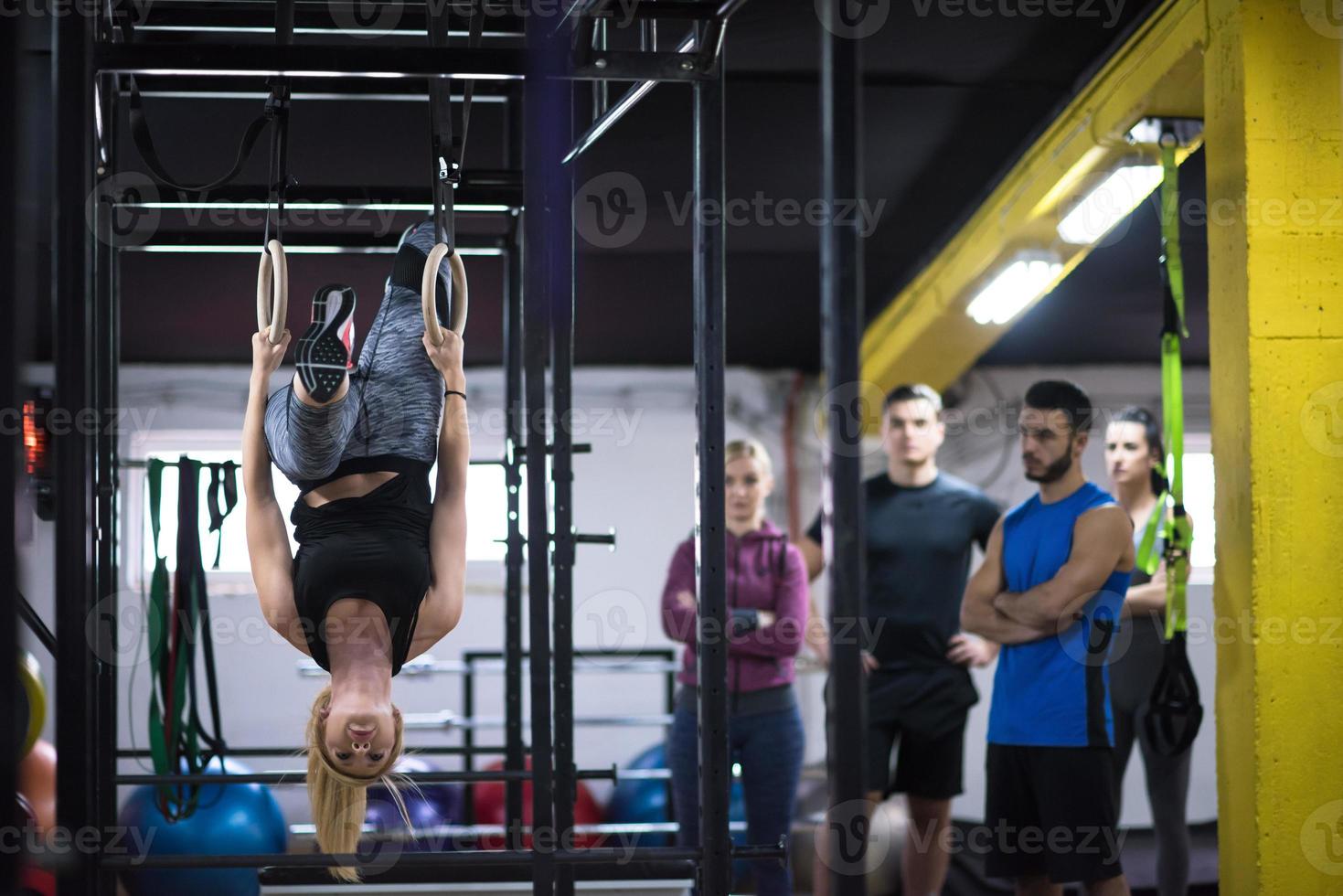 donna Lavorando su con personale allenatore su ginnastica anelli foto