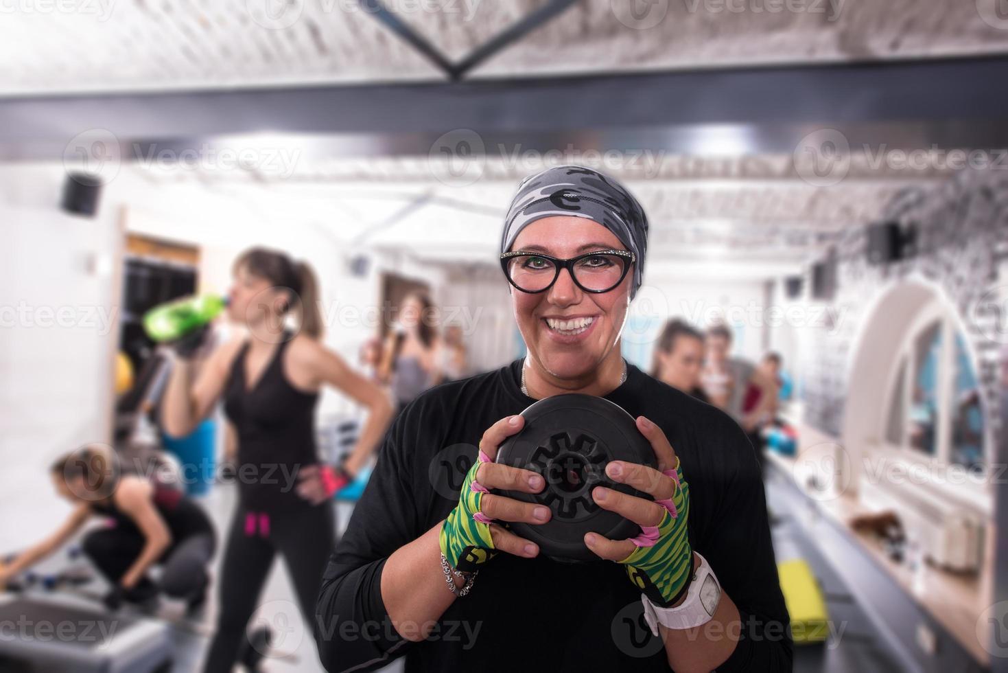 sportivo donna Tenere un' metallo il giro pesi piatto foto