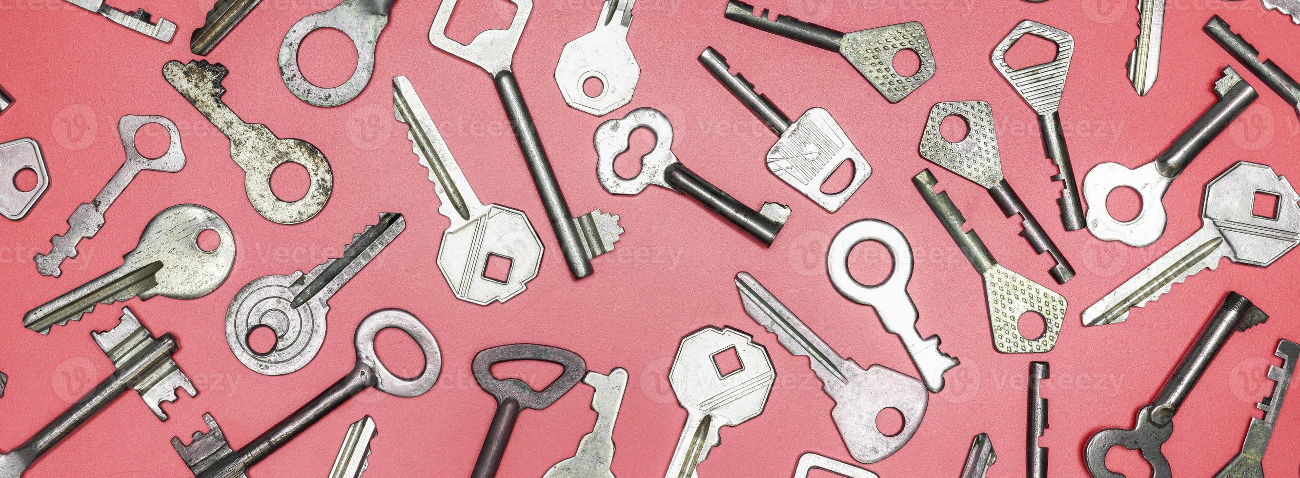 chiavi impostate su sfondo rosa. chiavi della serratura e casseforti per il corretto foto