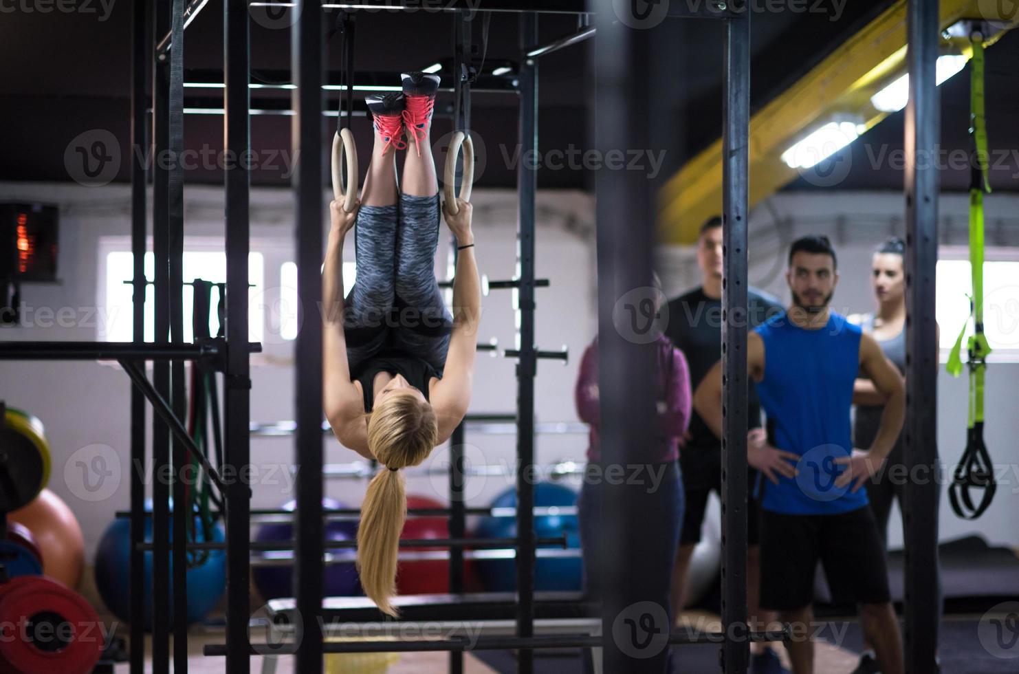 donna Lavorando su con personale allenatore su ginnastica anelli foto