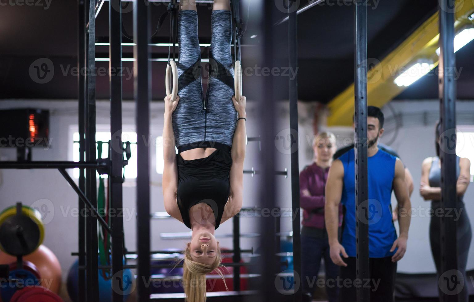 donna Lavorando su con personale allenatore su ginnastica anelli foto