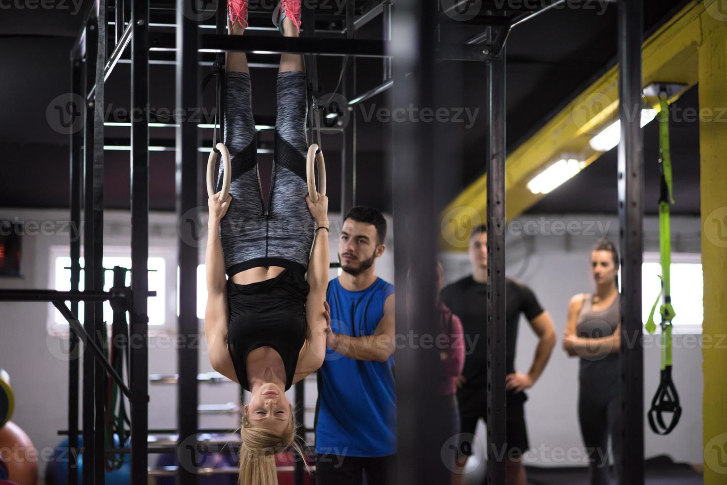 donna Lavorando su con personale allenatore su ginnastica anelli foto