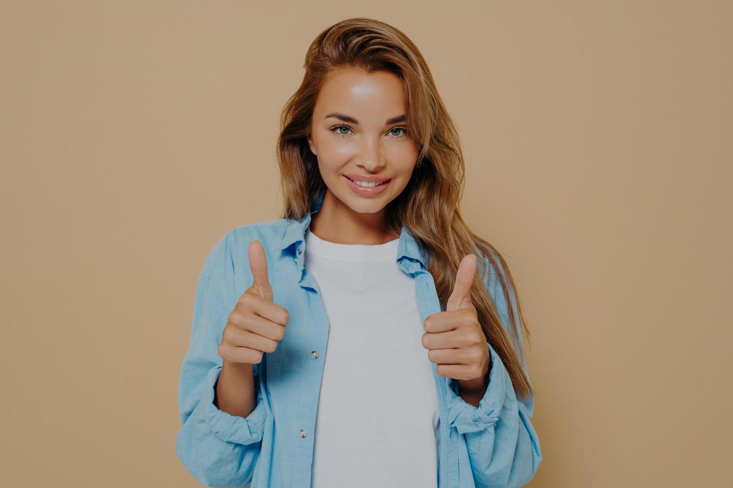 felice giovane donna che indossa una camicia a maniche lunghe blu su maglietta bianca foto