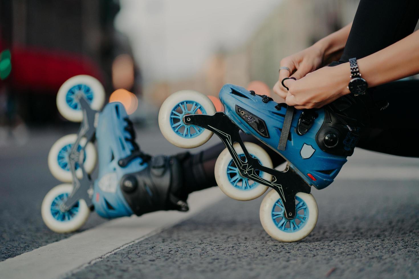 orizzontale tiro di senza volto donna mette su pattini cavalcate su strada pose contro urbano sfondo coinvolto nel attivo sport. persone passatempo ricreazione estremo sport attivo stile di vita concetto. foto