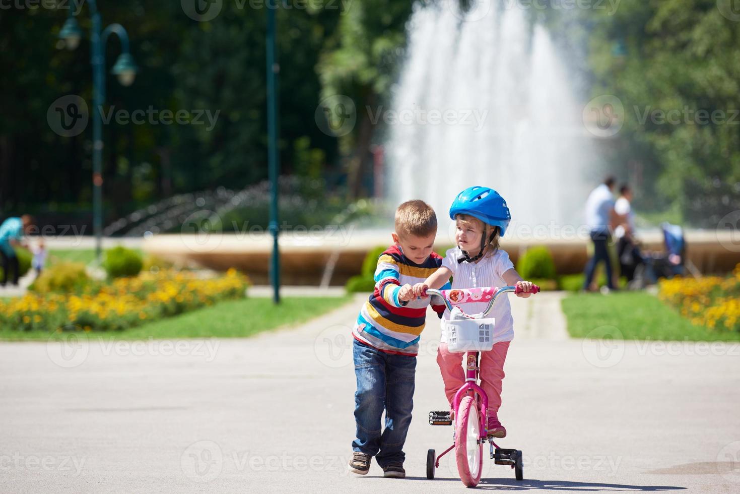 ragazzo e ragazza nel parco apprendimento per cavalcata un' bicicletta foto