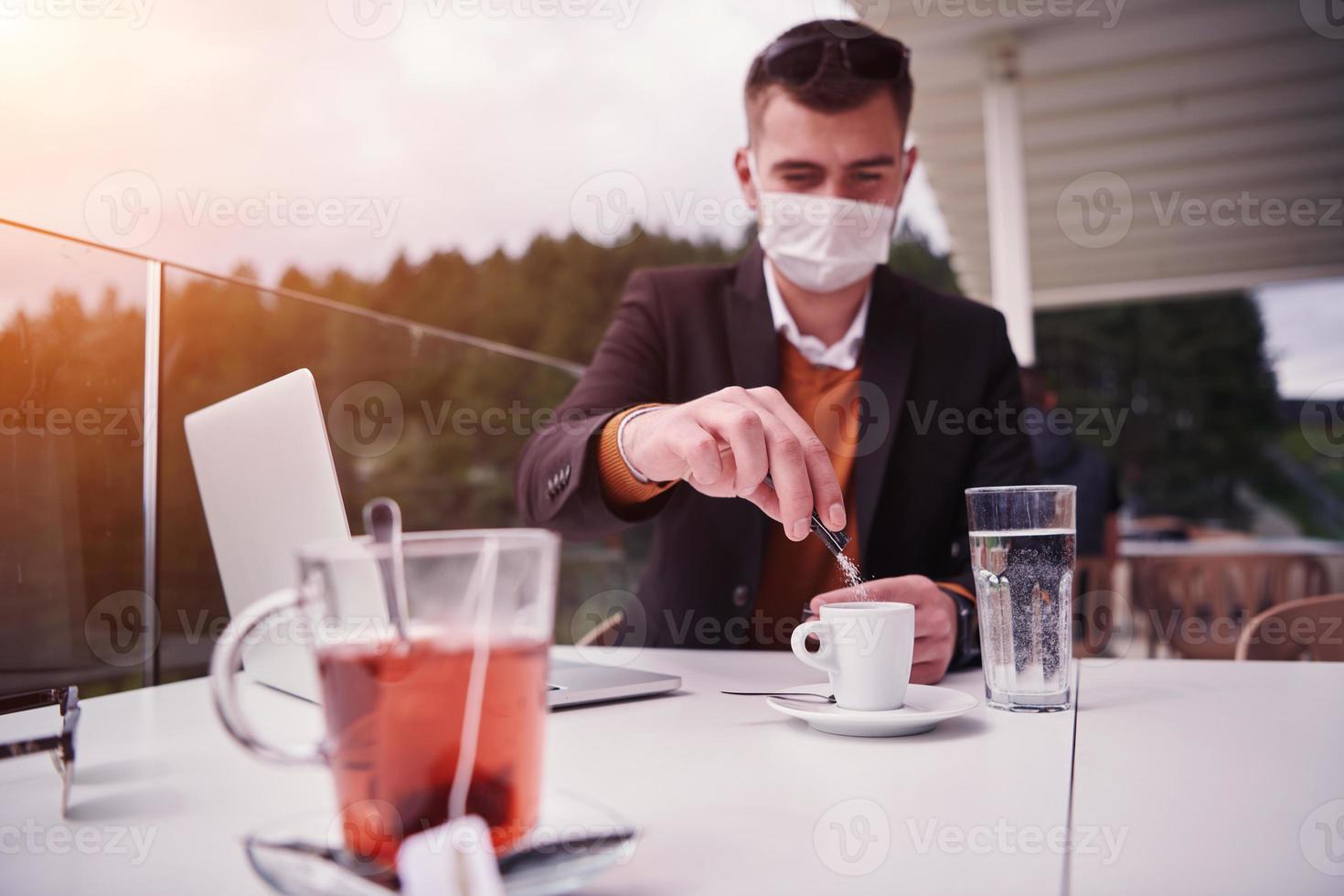 uomo nel ristorante potabile caffè indossare viso maschera foto