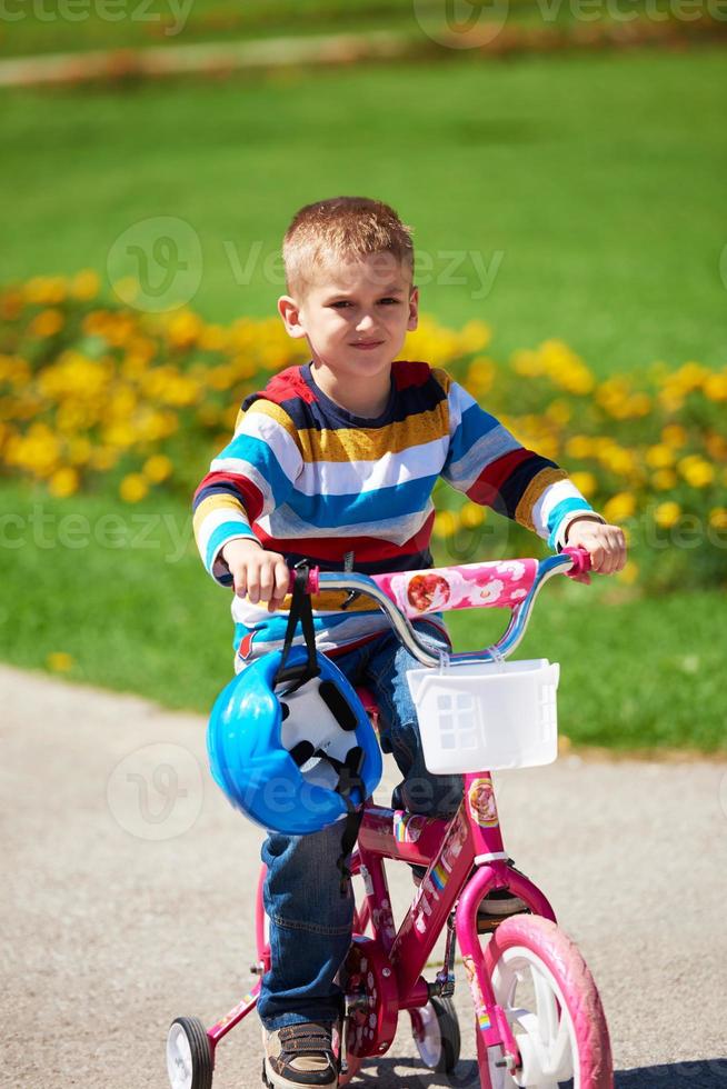 contento ragazzo apprendimento per cavalcata il suo primo bicicletta foto