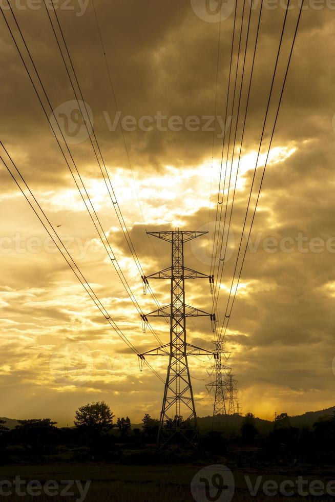 sole ambientazione dietro a il silhouette di elettricità piloni - vivace colore effetto foto