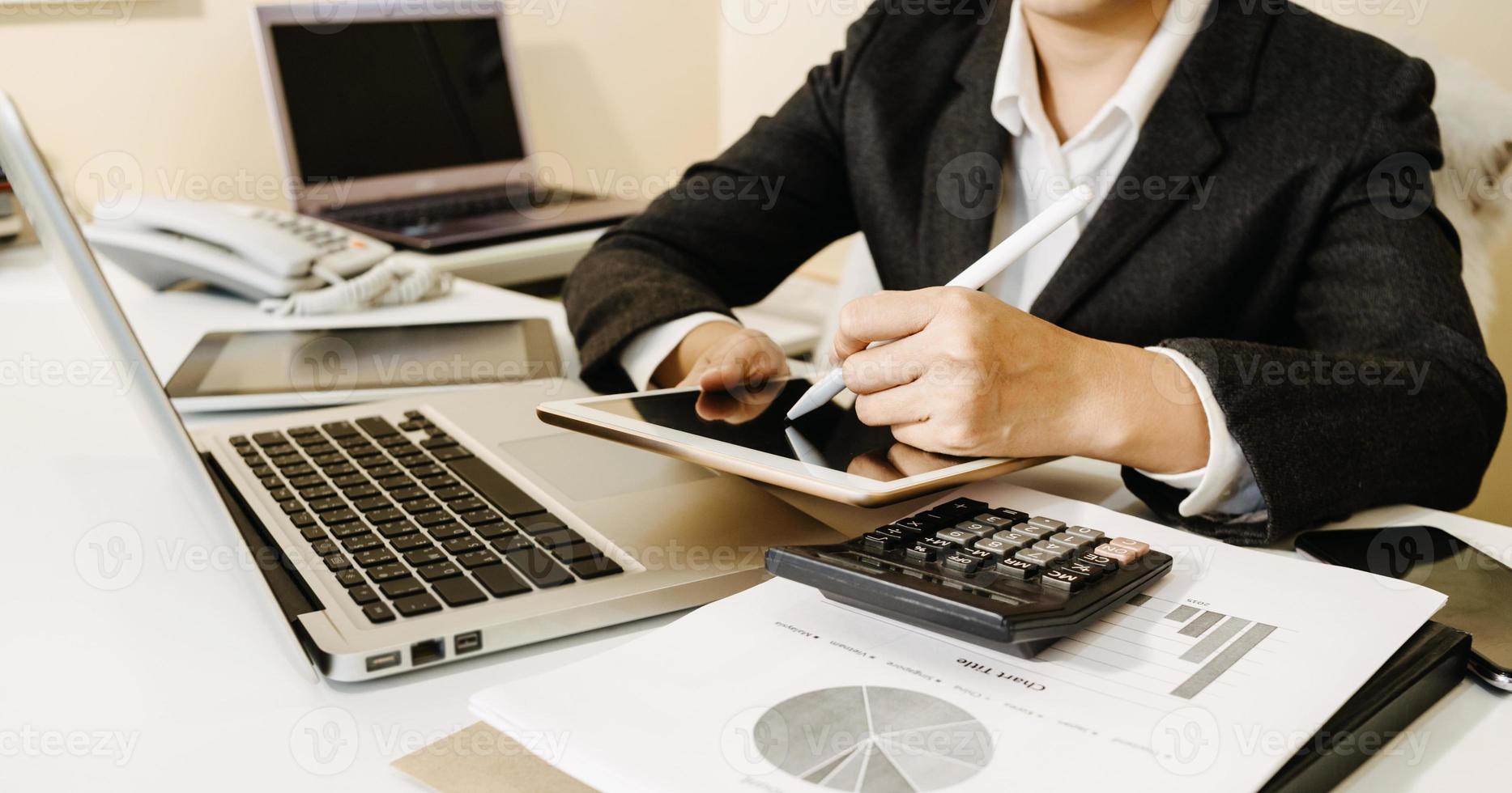 concetto di contabilità aziendale, uomo d'affari che utilizza la calcolatrice con computer portatile, budget e carta di prestito in ufficio. foto