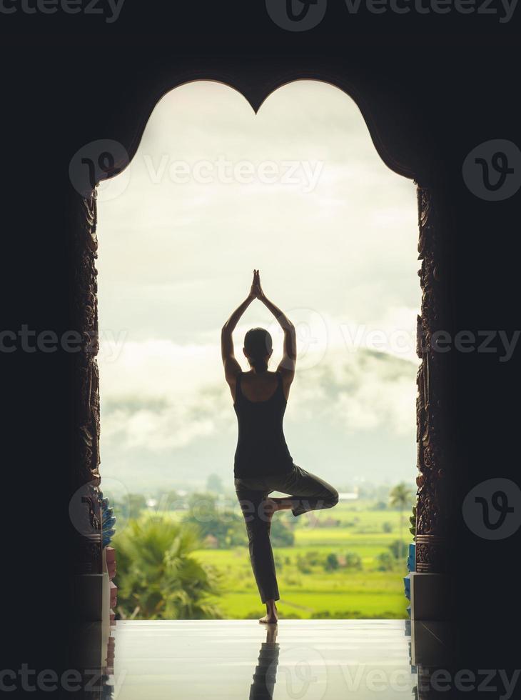 silhouette giovane donna praticante yoga su il tempio a tramonto - Vintage ▾ stile colore effetto foto