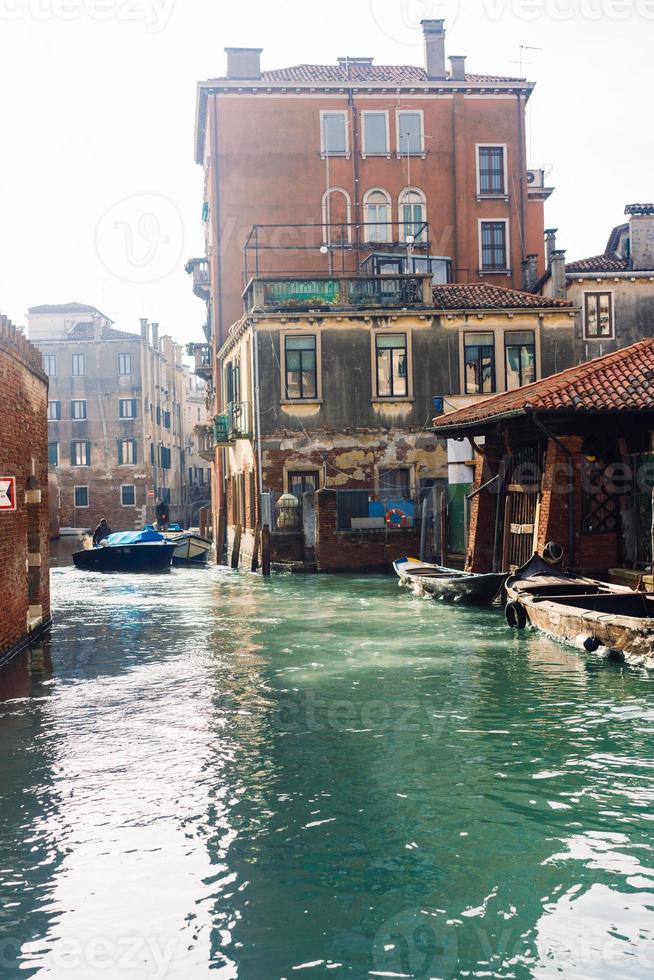 veneziano canale con antico case e Barche foto