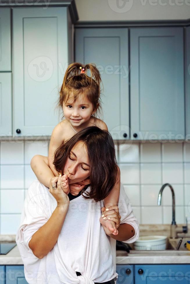 bellissimo poco figlia piggybacking su sua contento madre foto