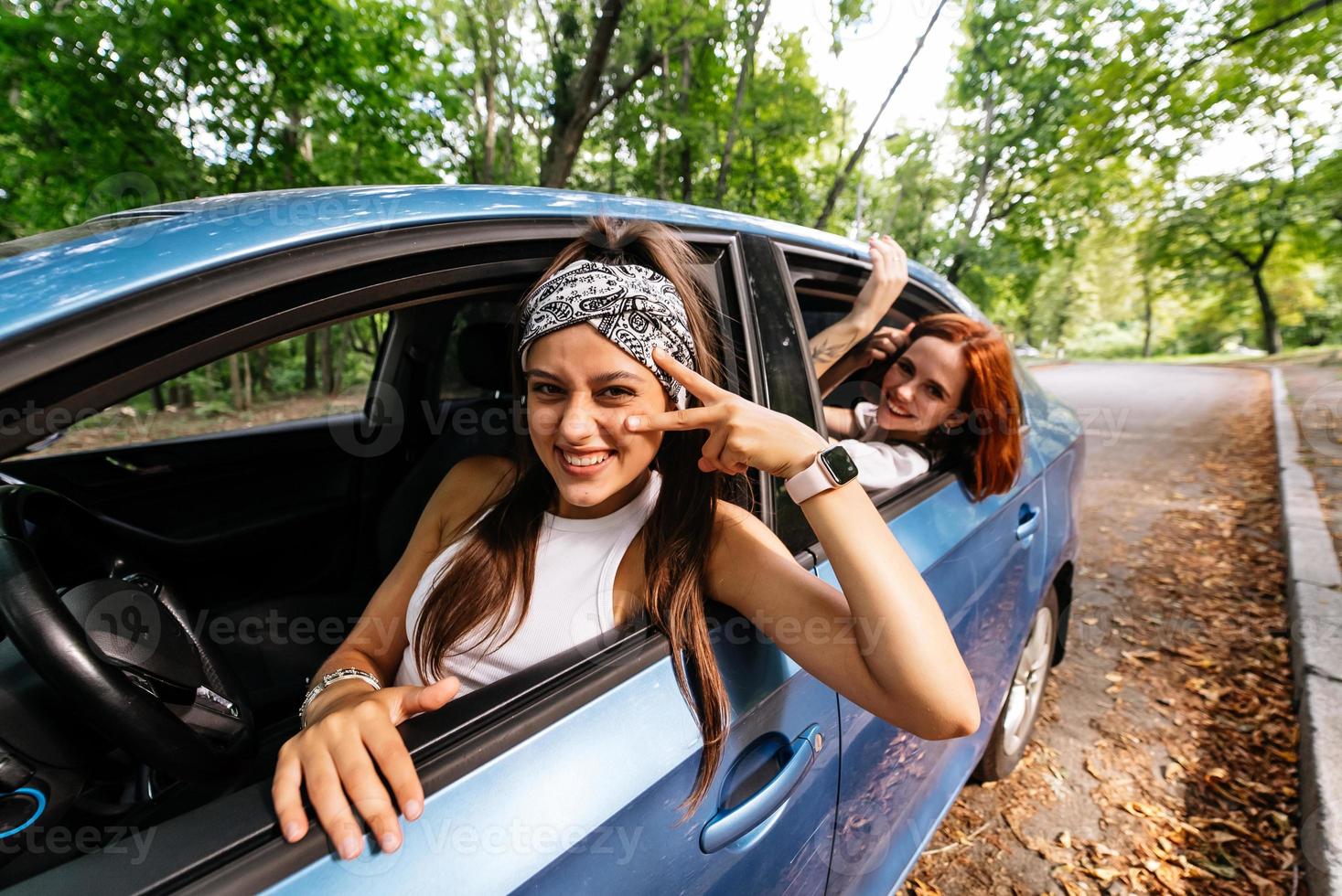 Due amiche scemo in giro e ridendo insieme nel un' auto foto