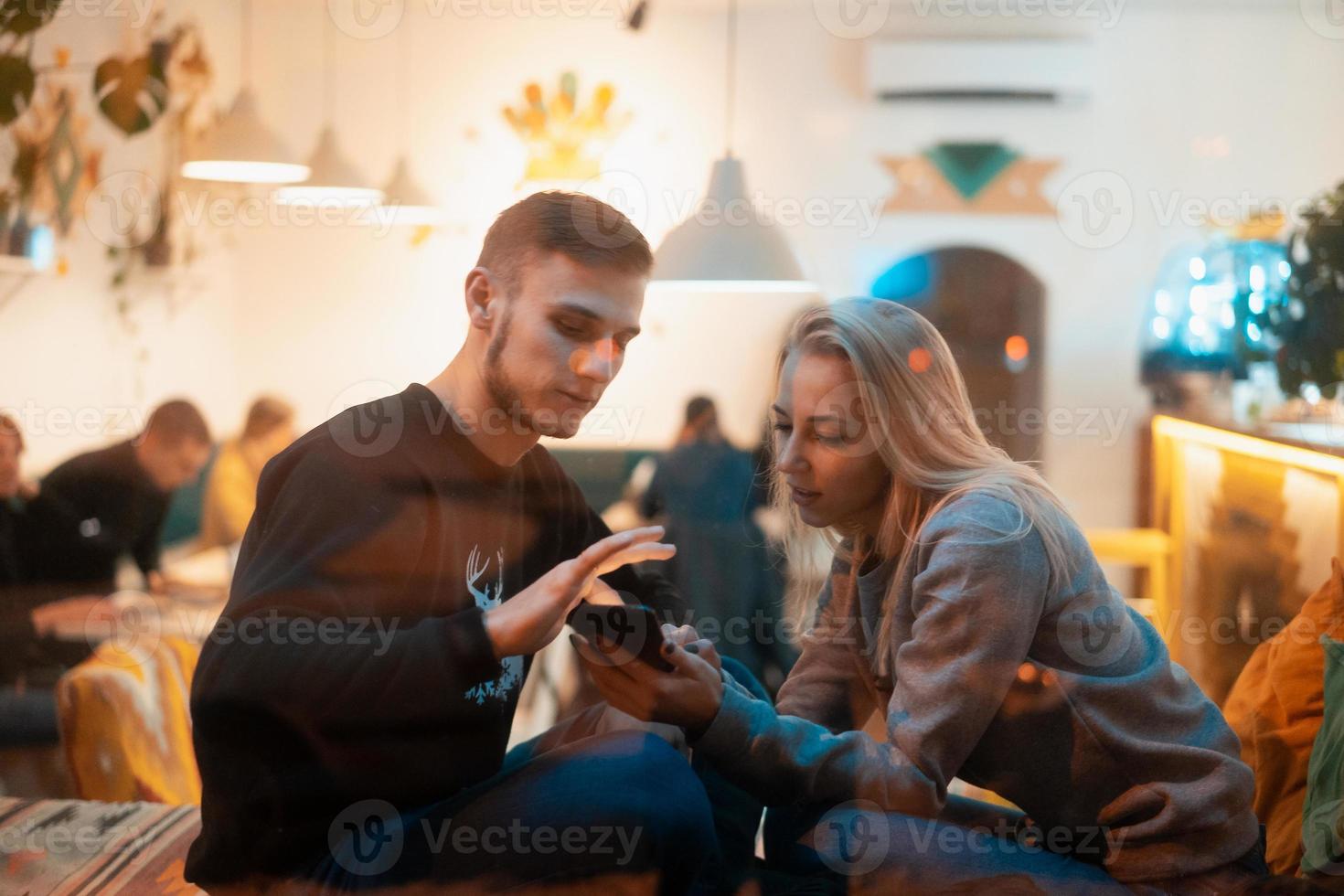 foto attraverso finestra. giovane coppia nel bar con elegante interno