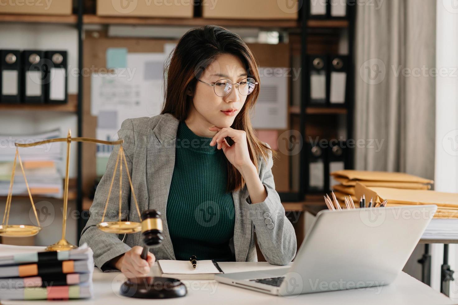 bellissimo asiatico donna avvocato Lavorando e martelletto, tavoletta, il computer portatile nel davanti, consigli giustizia e legge concetto. foto