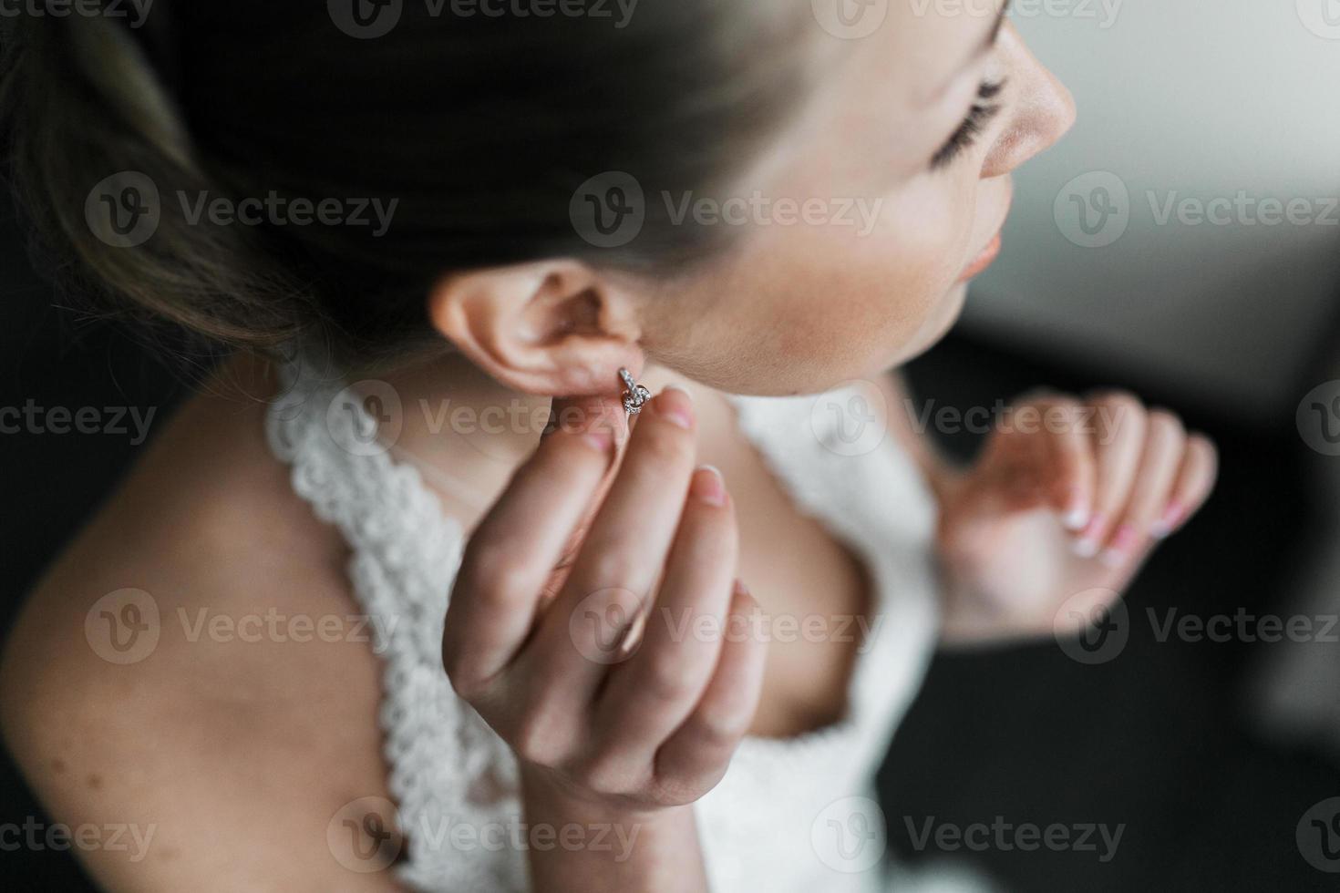 sposa mette su orecchini foto