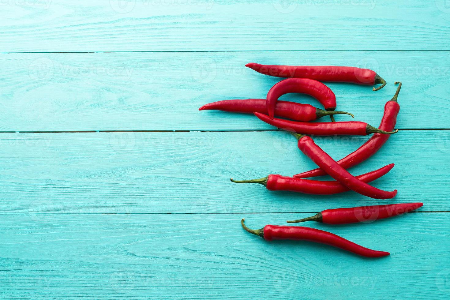 rosso pepers su blu di legno cucina sfondo. copia spazio e finto su foto