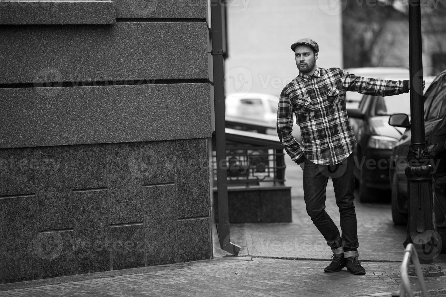 l'uomo con gli stivali autentici e i jeans a cimosa sullo sfondo della città vecchia foto