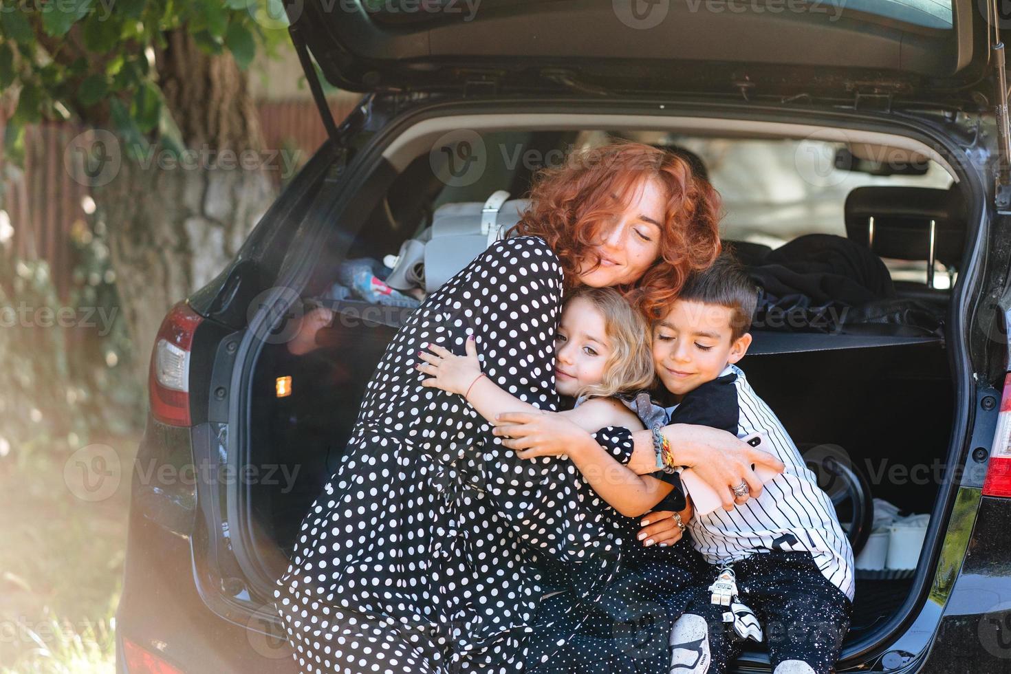 contento donna seduta con sua bambini nel il auto foto