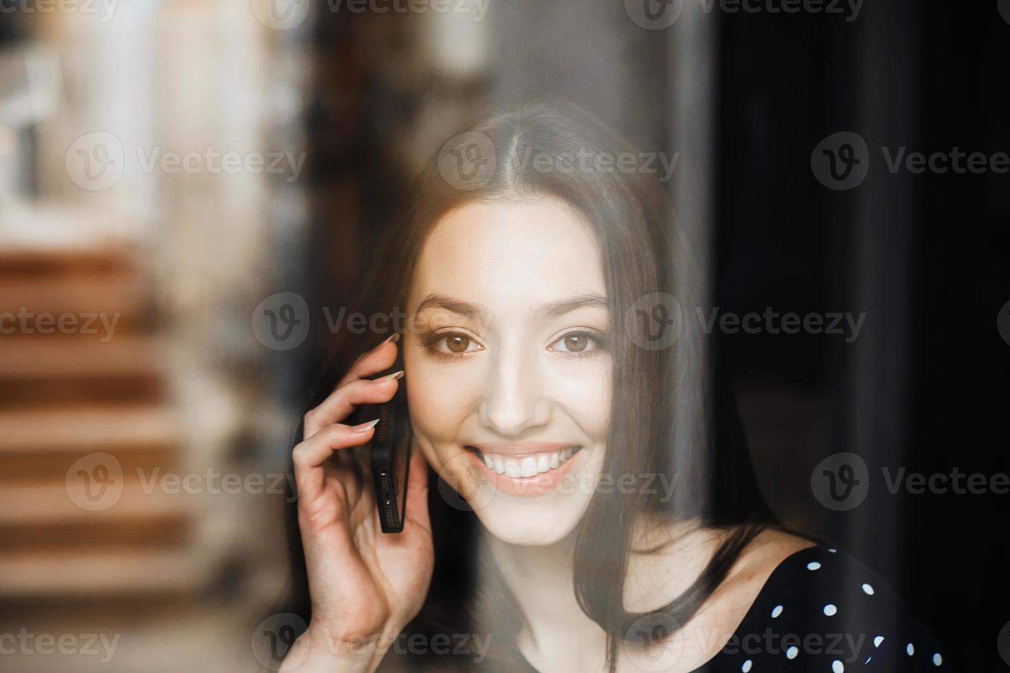 bella ragazza parla al telefono e sorride foto