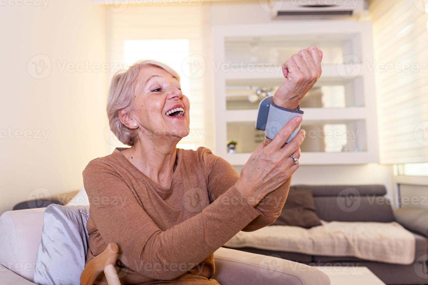 Salute concetto anziano donne è assunzione cura per Salute con sangue pressione monitor. alto sangue pressione. maturo donna misurazione sangue pressione a casa foto