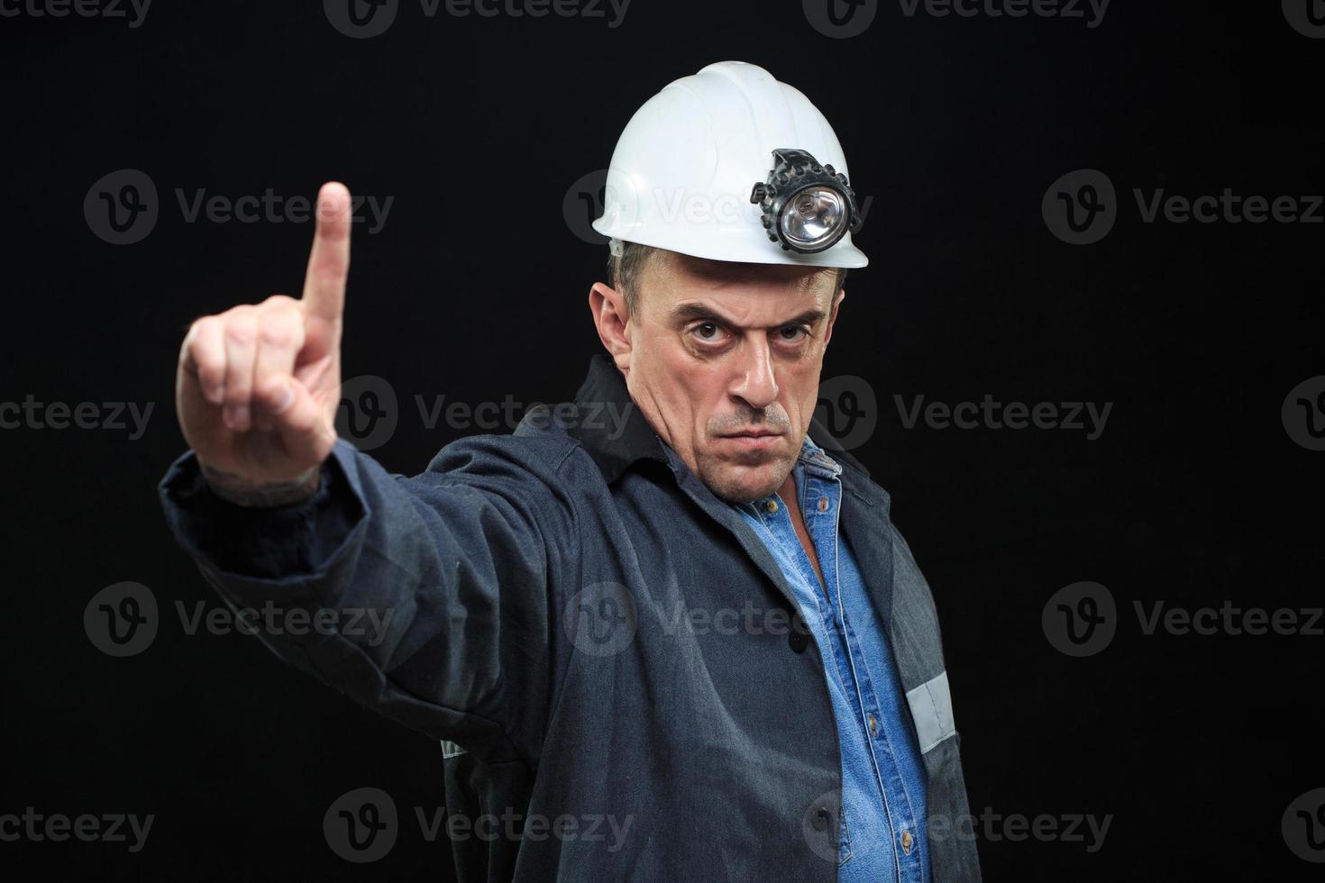uomo con cappello da minatore di carbone e dito punti di abbigliamento di sicurezza foto