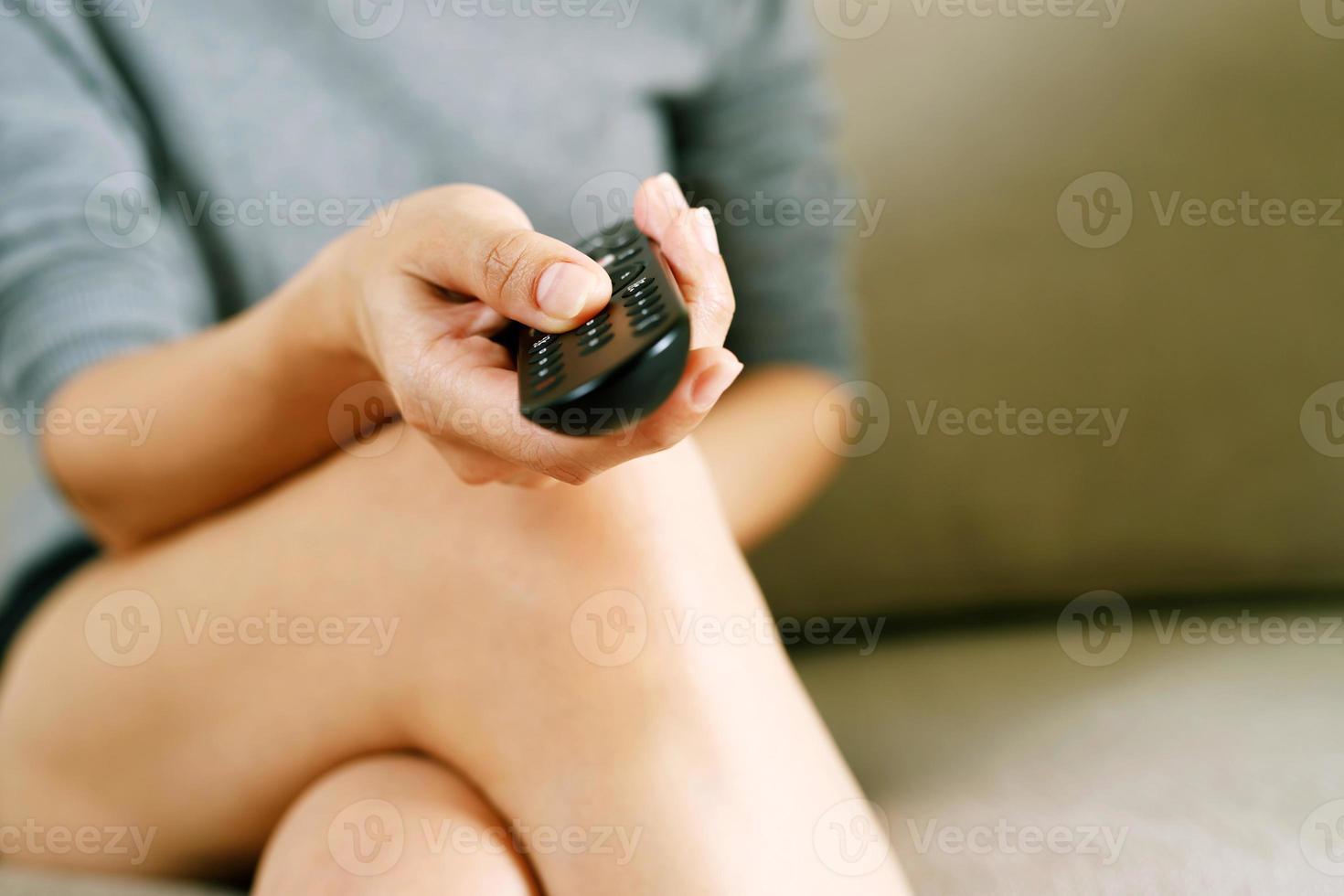 vicino su televisione a distanza controllo nel casuale uomo mano hold puntamento per tv impostato e svolta esso su o spento. Selezionare canale Guardando calcio gioco su tv il suo a casa nel il vivente camera relax. foto