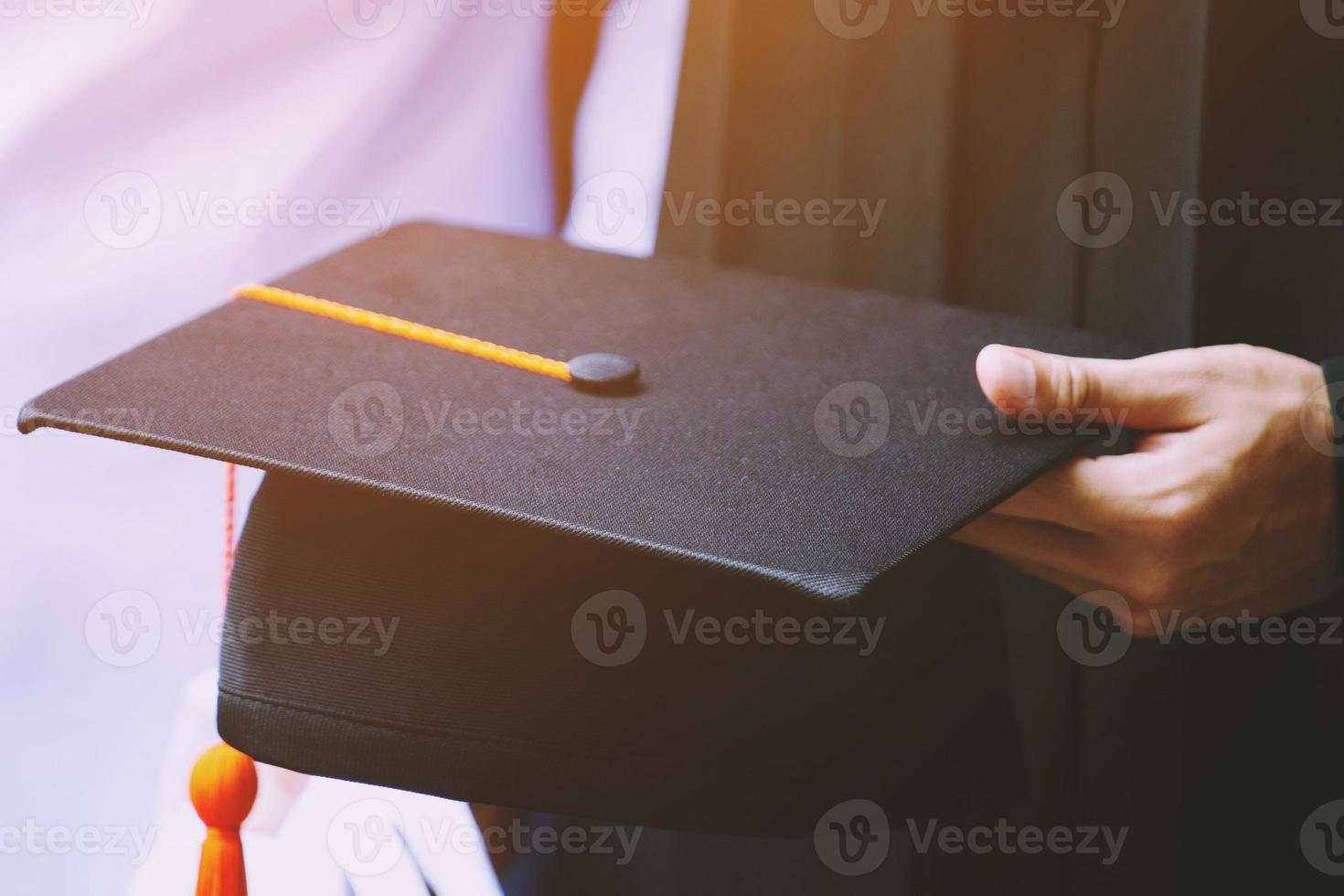 alunno hold cappello nel mano durante avvio successo laureati di il università, concetto formazione scolastica congratulazioni. la laurea cerimonia. morbido messa a fuoco foto