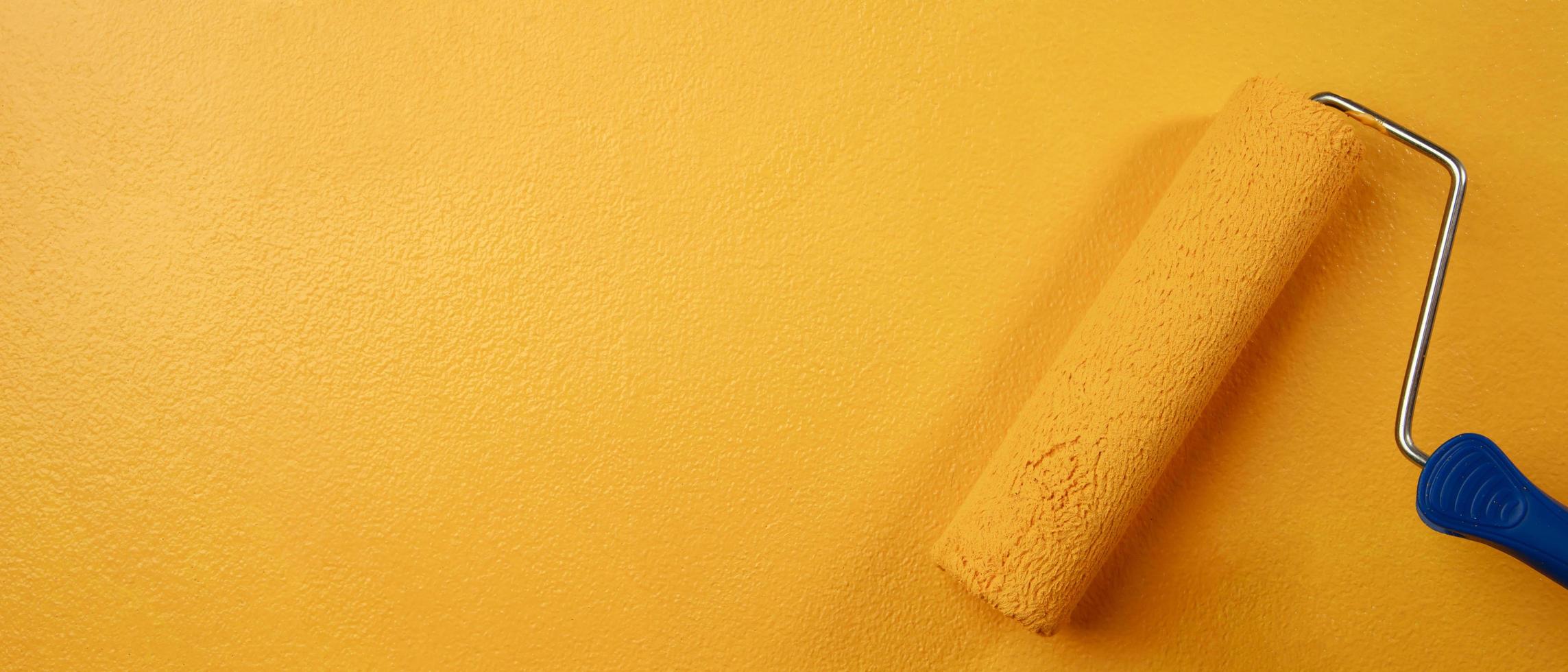 rullo spazzola la pittura, lavoratore pittura su superficie parete pittura appartamento, Restaurare con giallo colore dipingere. partire vuoto copia spazio bianca per Scrivi descrittivo testo accanto. foto
