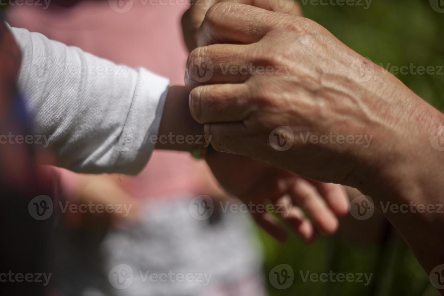 anziano donna di mani nel il luce del sole foto