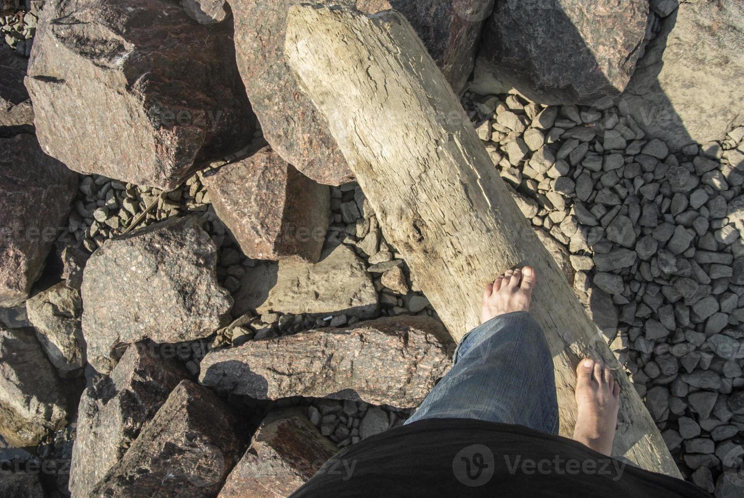 tipo passeggiate a piedi nudi su selvaggio spiaggia. piedi su tronco d'albero. foto