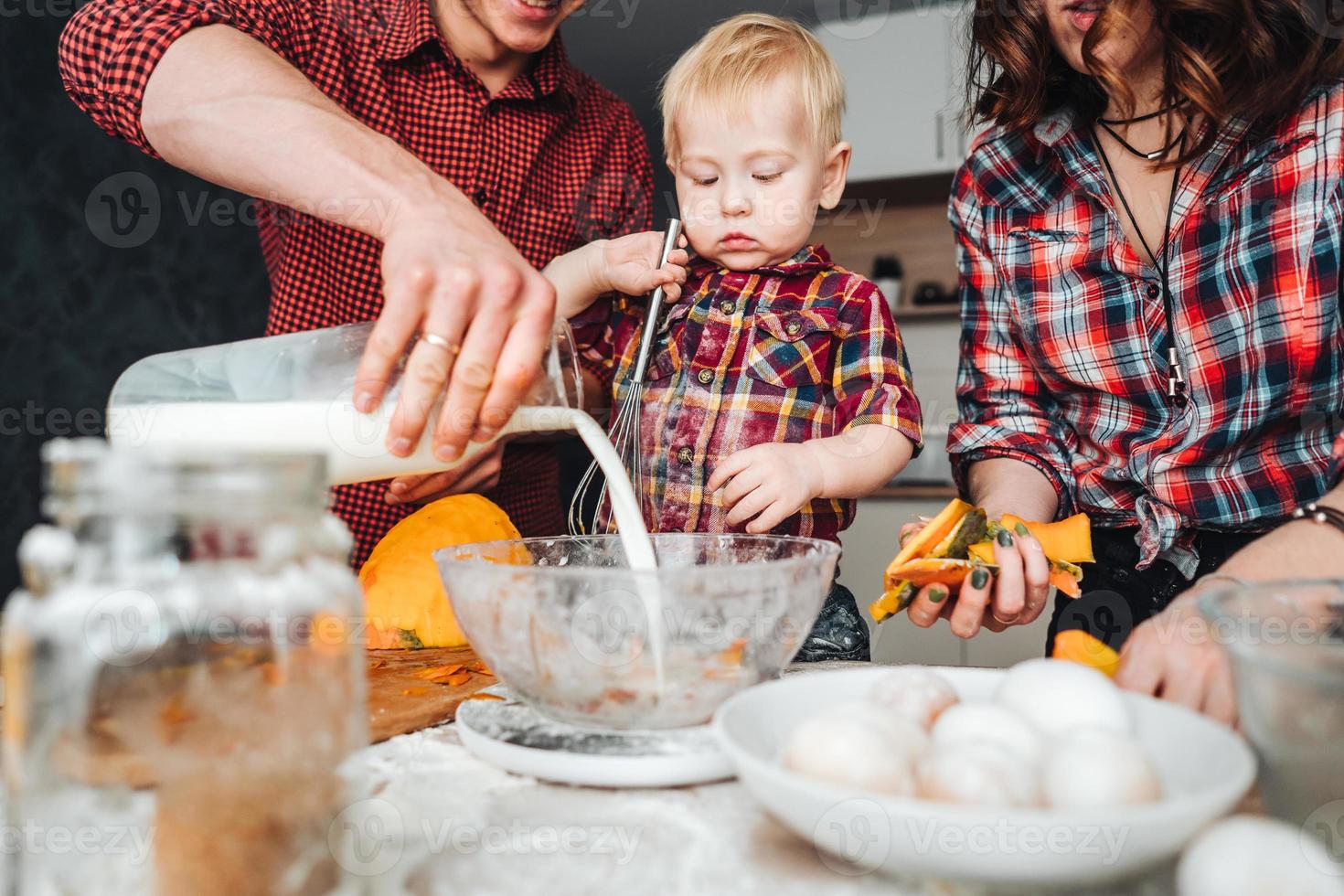 papà, mamma e poco figlio cucinare un' torta foto