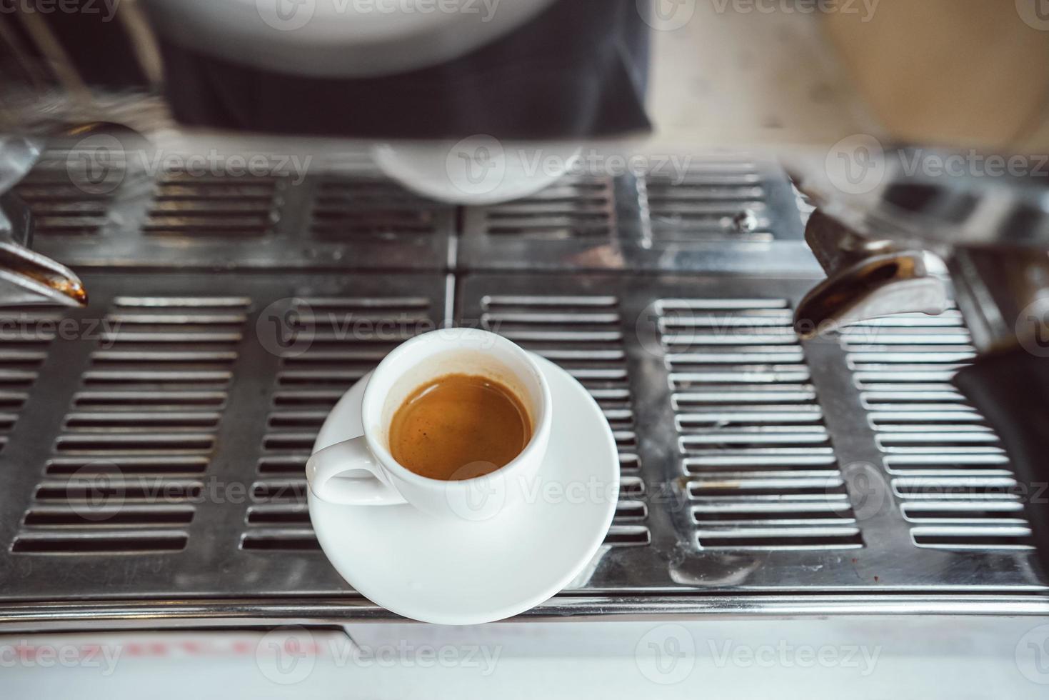 avvicinamento Visualizza di bicchiere tazza con cappuccino e caffè macchina foto