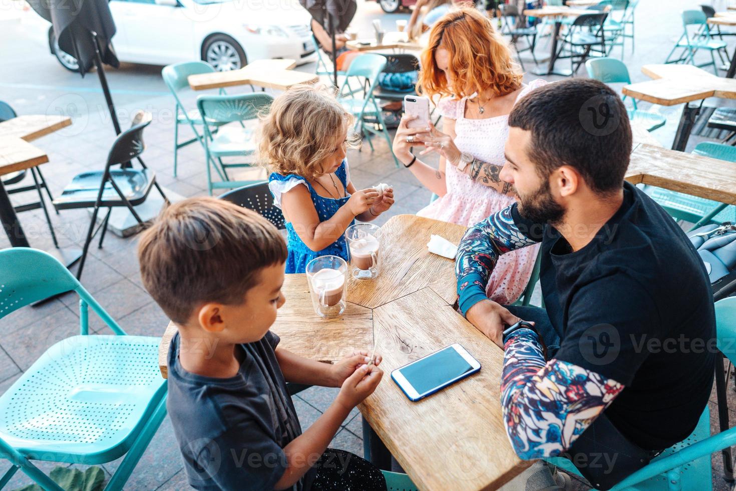 famiglia nel un' bar, mamma prende un' foto